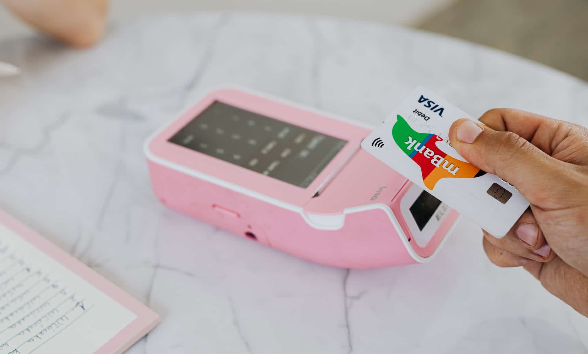 Imagem mostra pessoa aproximando cartão de máquina NFC. Bugs podem fazer máquinas NFC revelarem dados que permitam que cartões sejam clonados