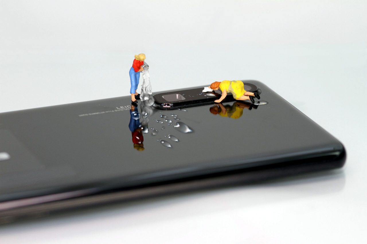 bonquinhas fazendo uma limpeza no celular para ilustrar a restauração de celulares para a configuração de fábrica