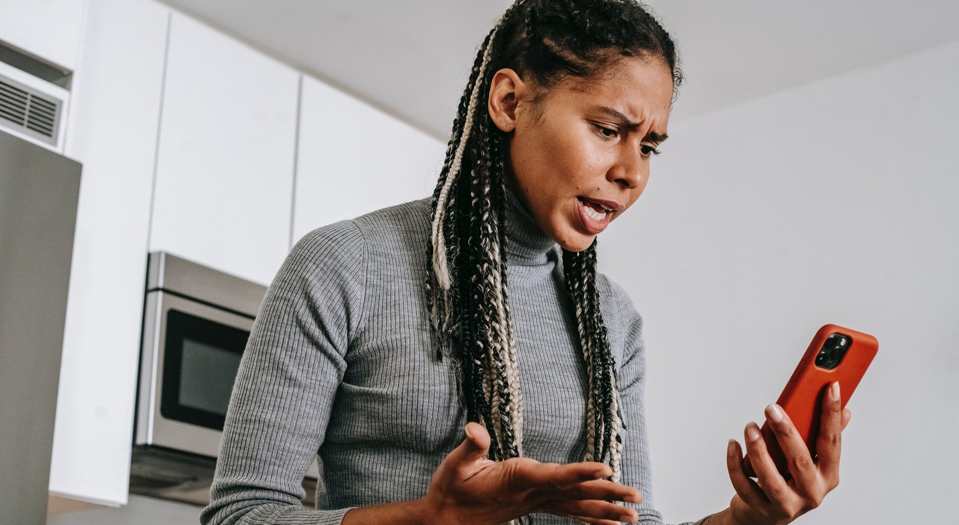 Mulher intrigada de frente para o computado para ilustrar que o Google vai ocultar sites de calúnia