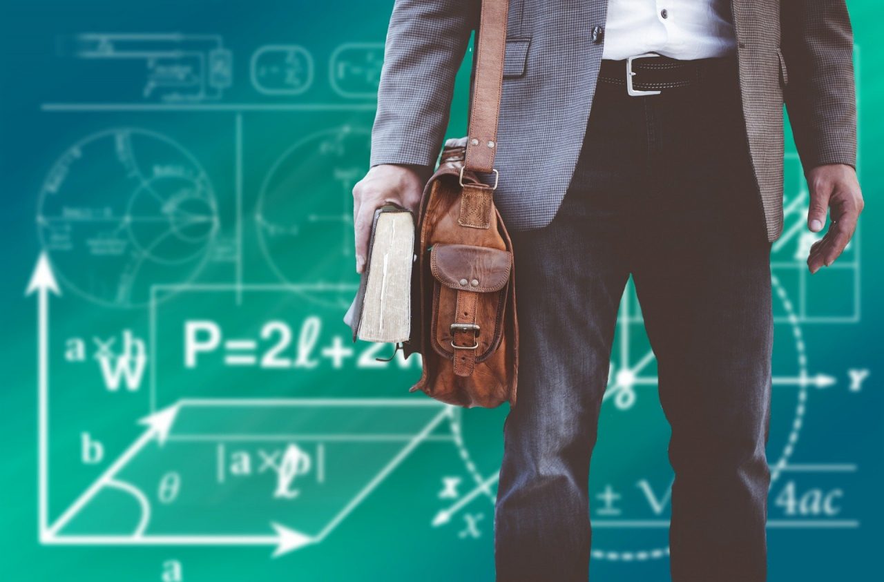 Jovem segura um livro em uma montagem com quadro cheio de fórmulas matemáticas