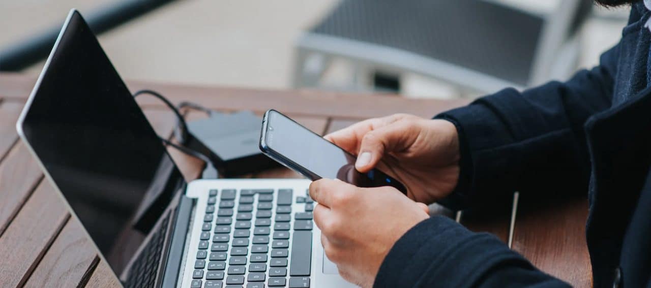 Homem com um celular e um computador
