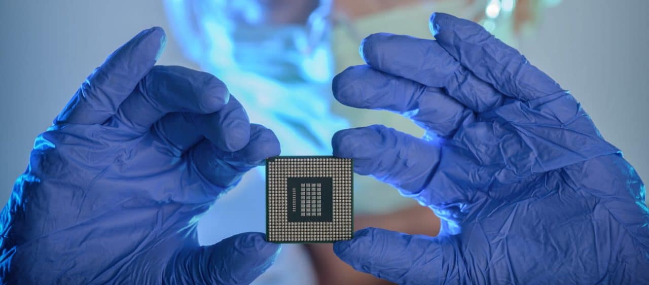 Imagem mostra pessoa segurando chip, simbolizando que escassez de chips pode prejudicar lucros da Apple