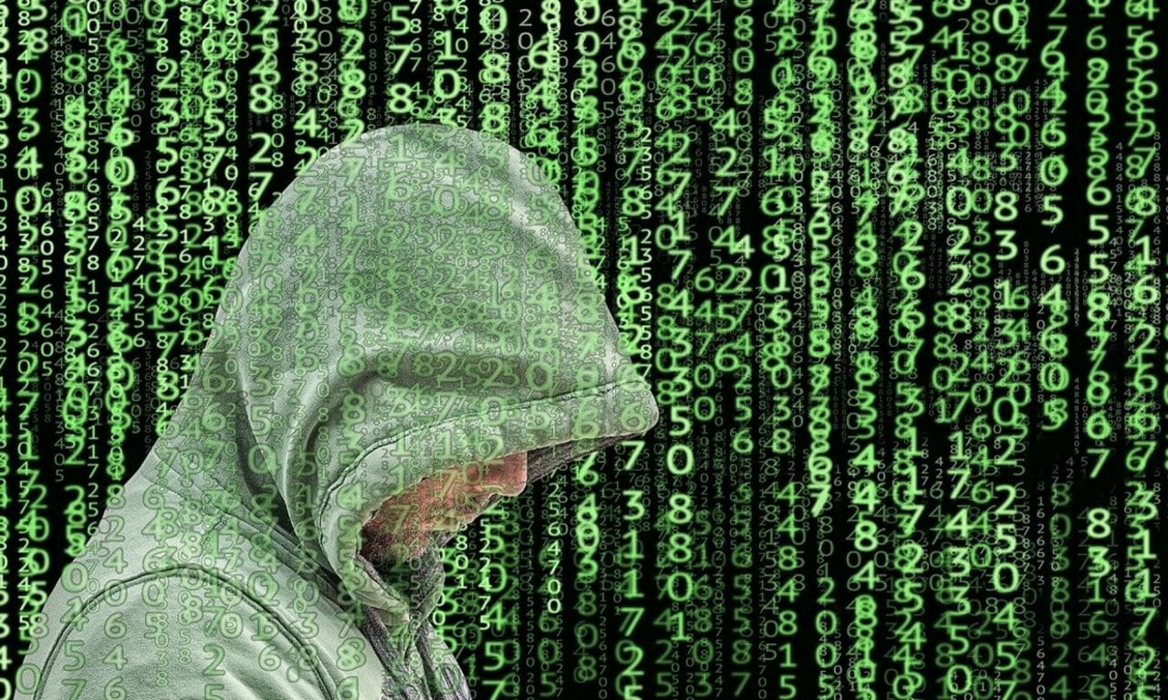 Imagem mostra pessoa de capuz verde e sequência de números passando atrás, simbolizando falha de segurança que atingiu gerenciador de senhas da Kaspersky