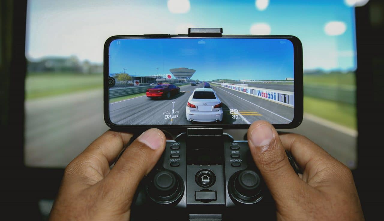 Imagem mostra pessoa jogando no celular com joystick, simbolizando que Netflix entrará no mercado de games para celular