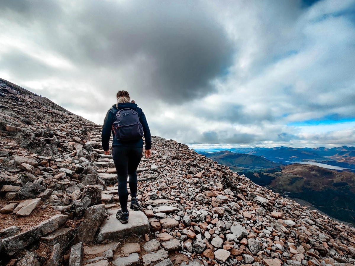 Mulher escalando a montanha de Ben Nevis, na Escócia
