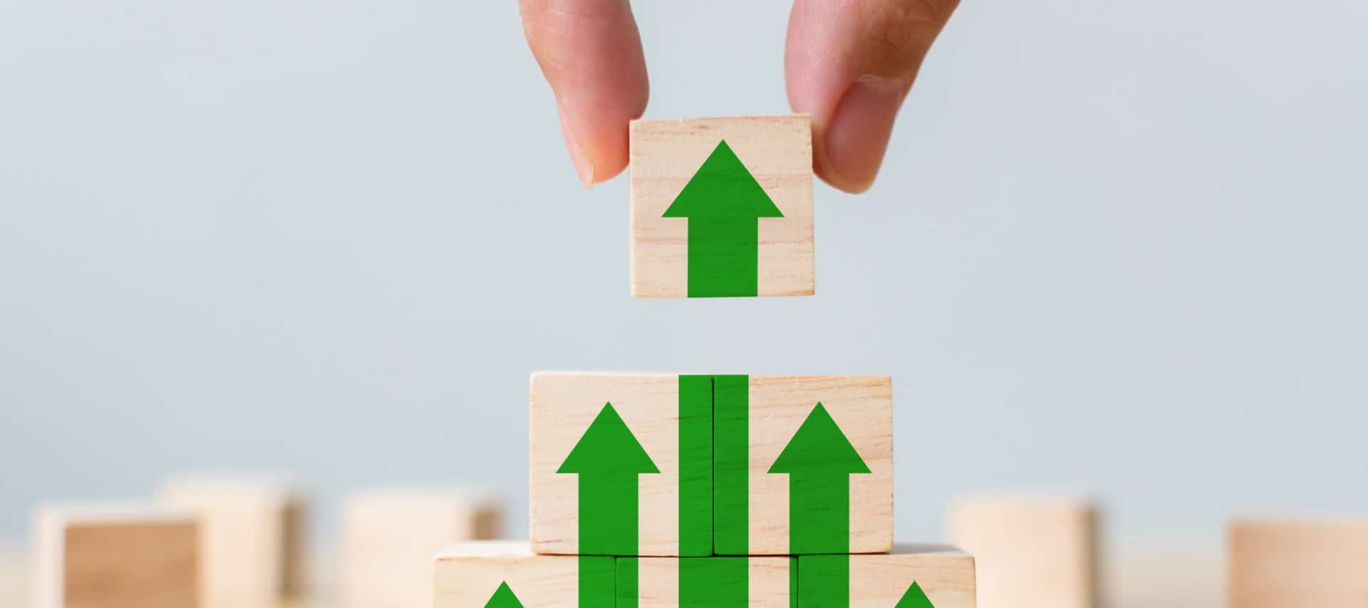 Imagem mostra homem colocando bloco de madeira com seta verde para cima, representação de que a OnePlus segue como a empresa que mais cresce em vendas nos Estados Unidos