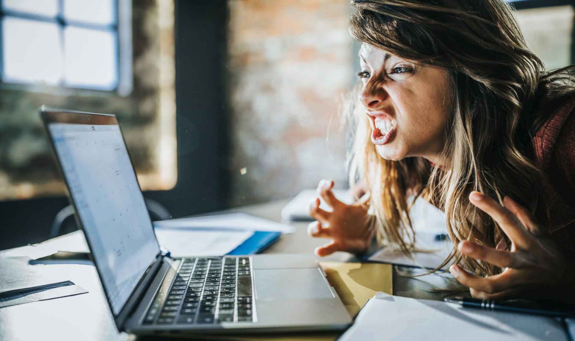 Imagem mostra pessoa brava com notebook, simbolizando a questão que tanto nos fazemos: por que o WhatsApp Web desconecta tanto?