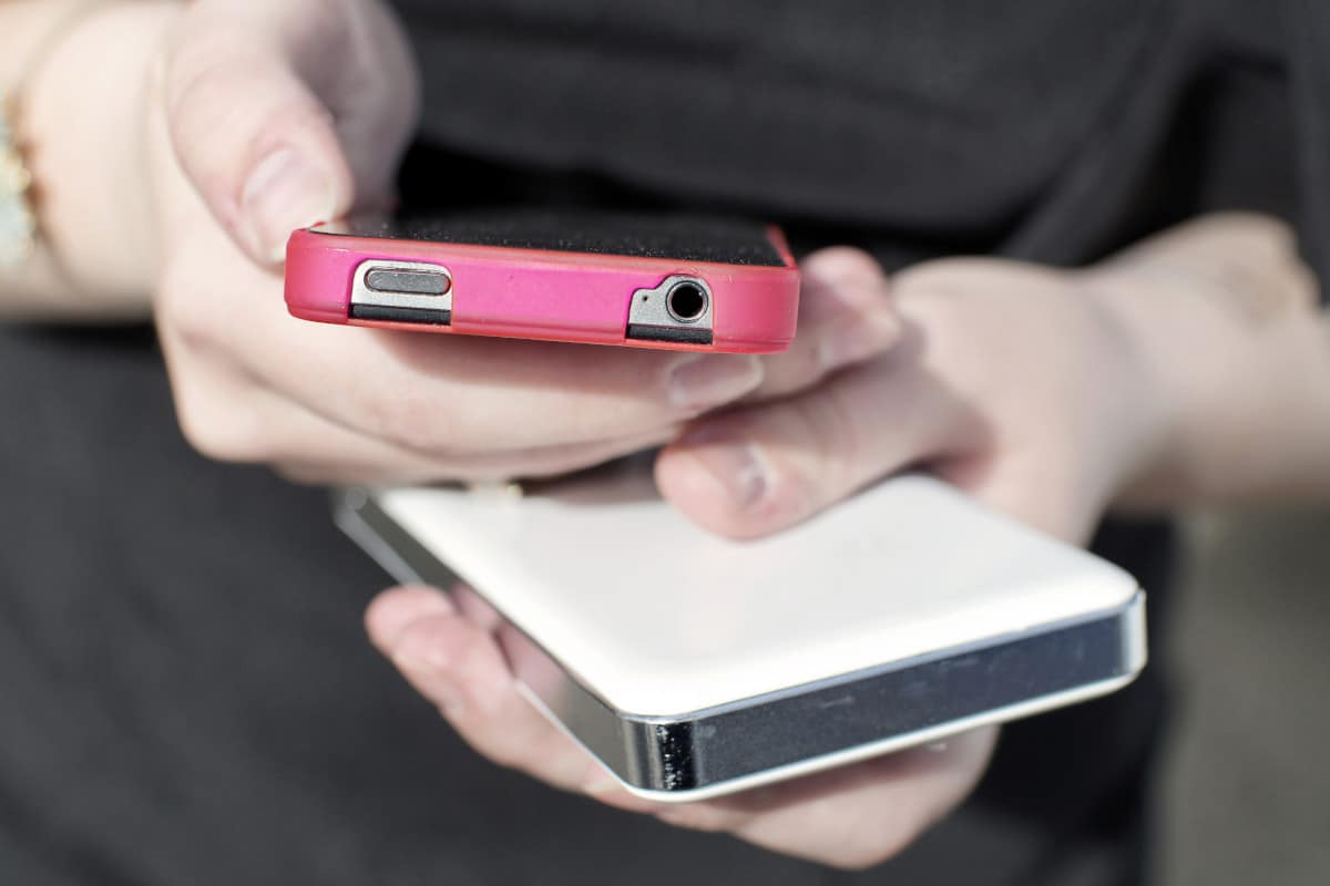 Foto de mulher com dois celulares na mão