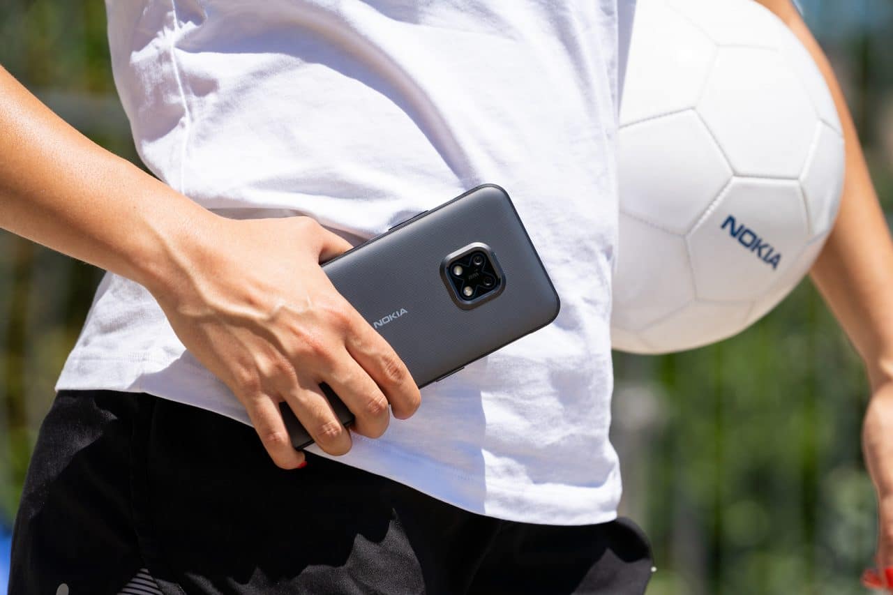 Nokia XR20 na mão com uma bola ao lado