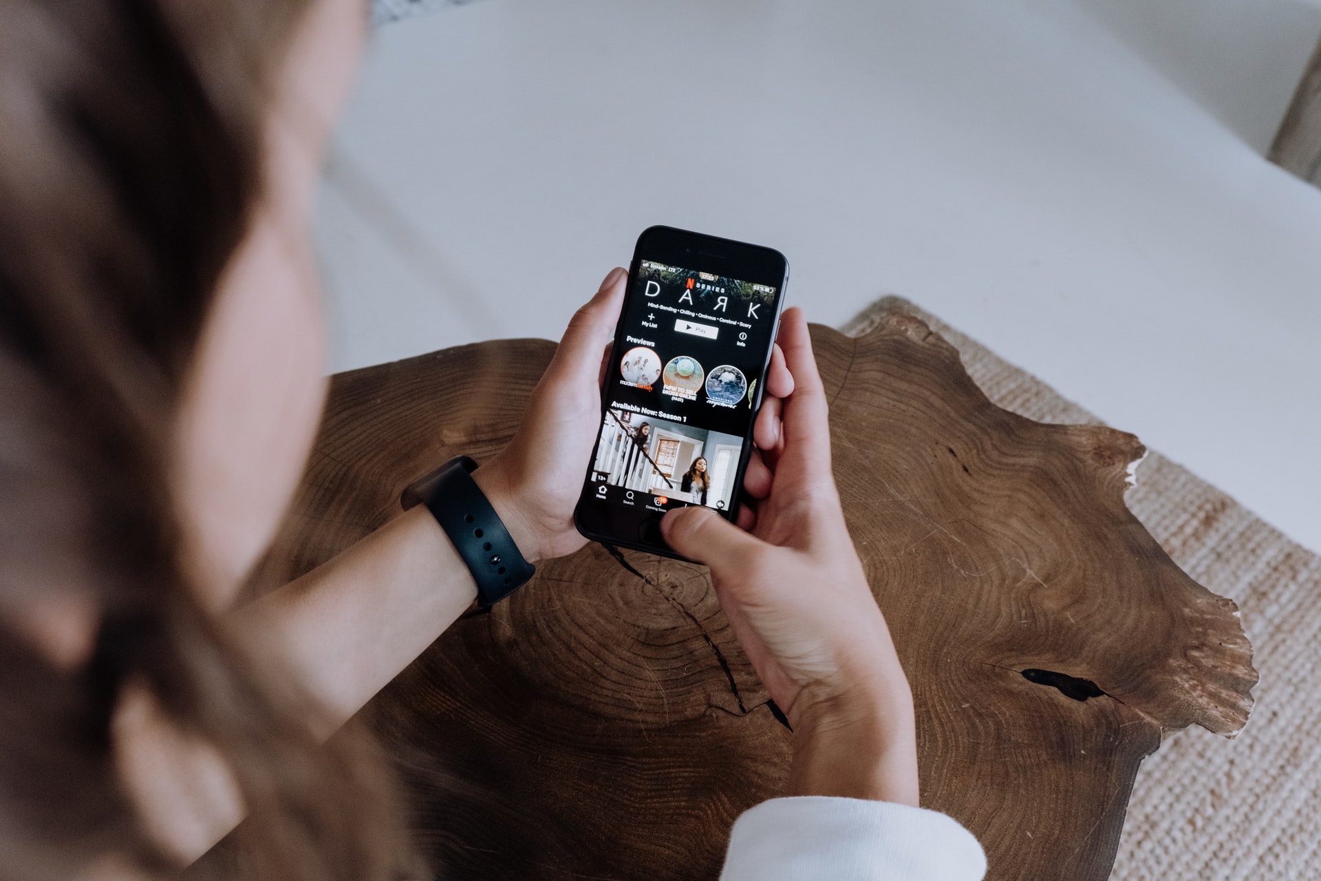 Pessoa usando a Netflix no celular para ilustrar a perda de usuários no EUA e no Canadá