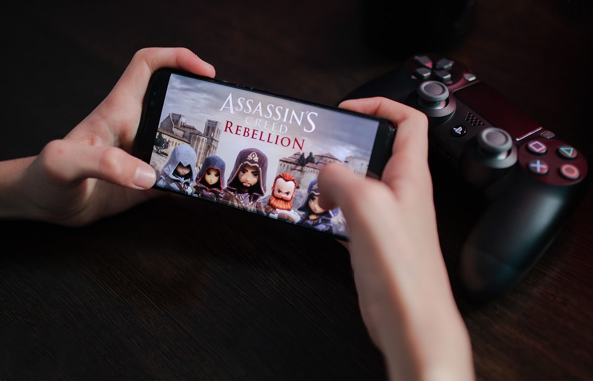 Anônimo jogando Assassins Creed: Rebellion, um dos principais jogos da Ubisoft, em um smartphone