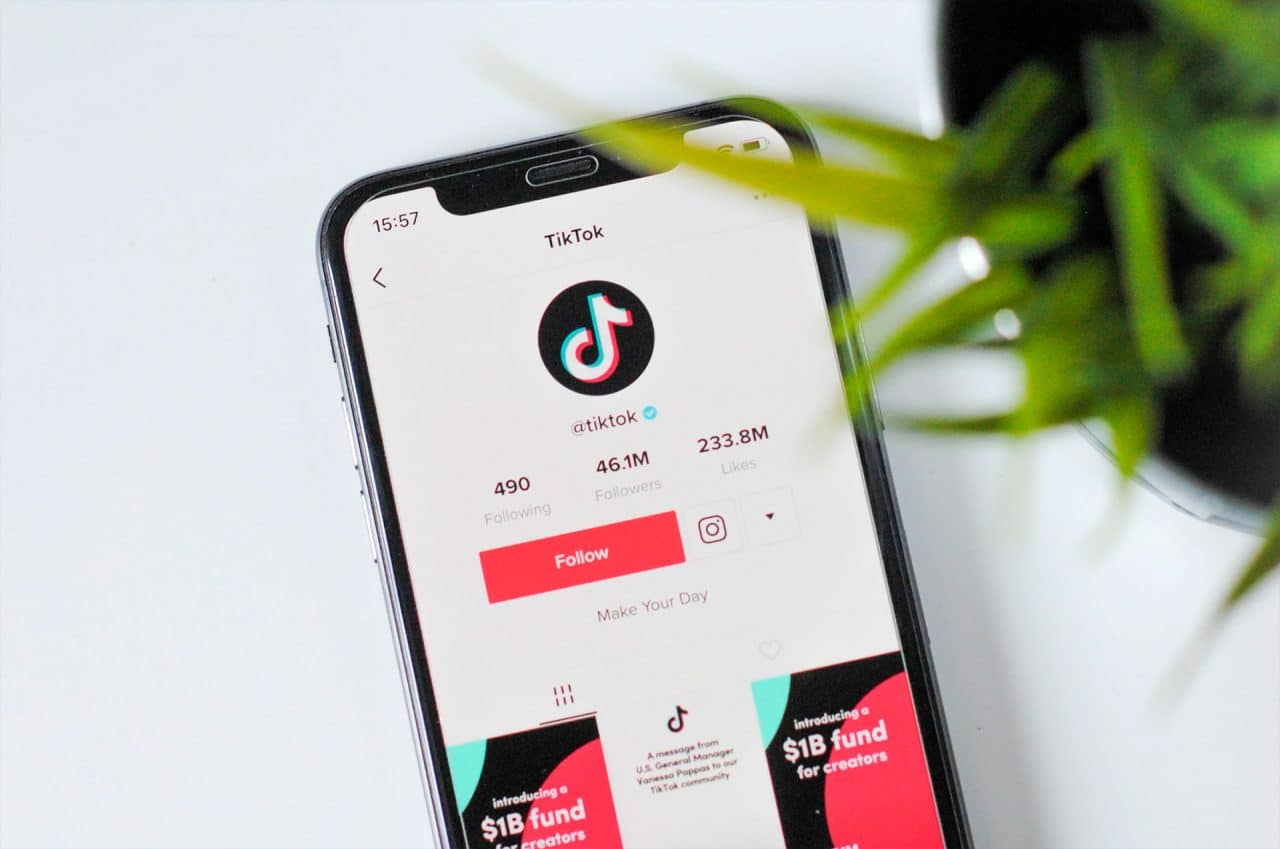 Imagem do aplicativo TikTok rodando em smartphone em cima da mesa
