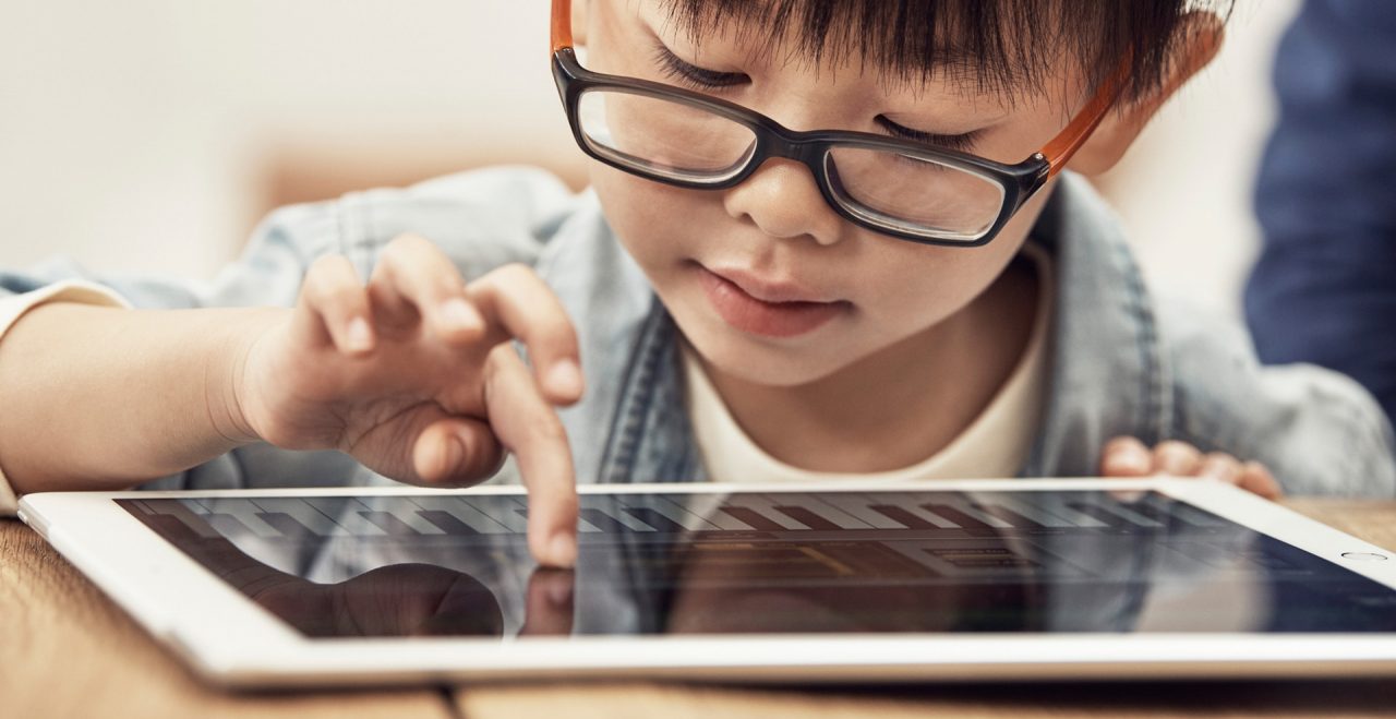 Criança usando o iPad da Apple, que pretende lançar um detector imagens de abuso infantil para o iOS