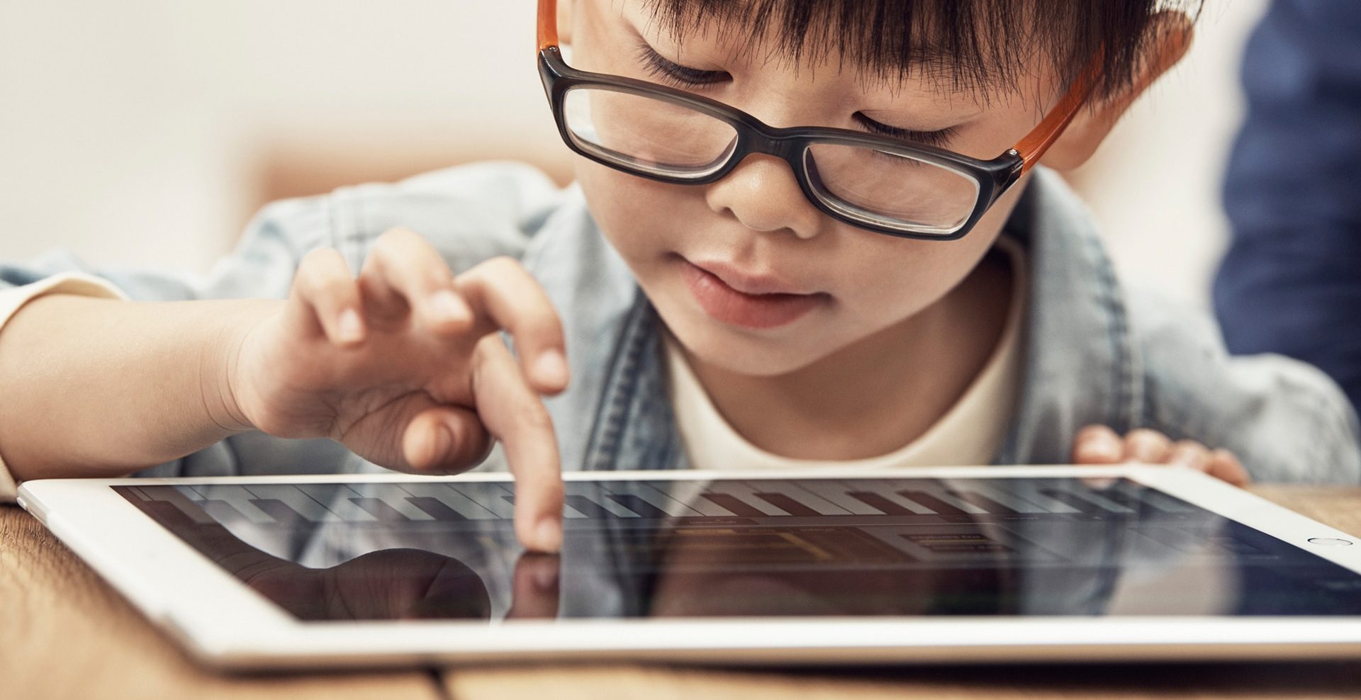 Criança usando o iPad da Apple, que pretende lançar um detector imagens de abuso infantil para o iOS