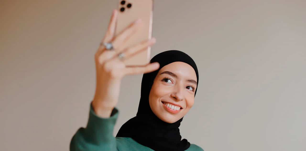 Mulher sorrindo para o celular. TikTok estudo sobre humor