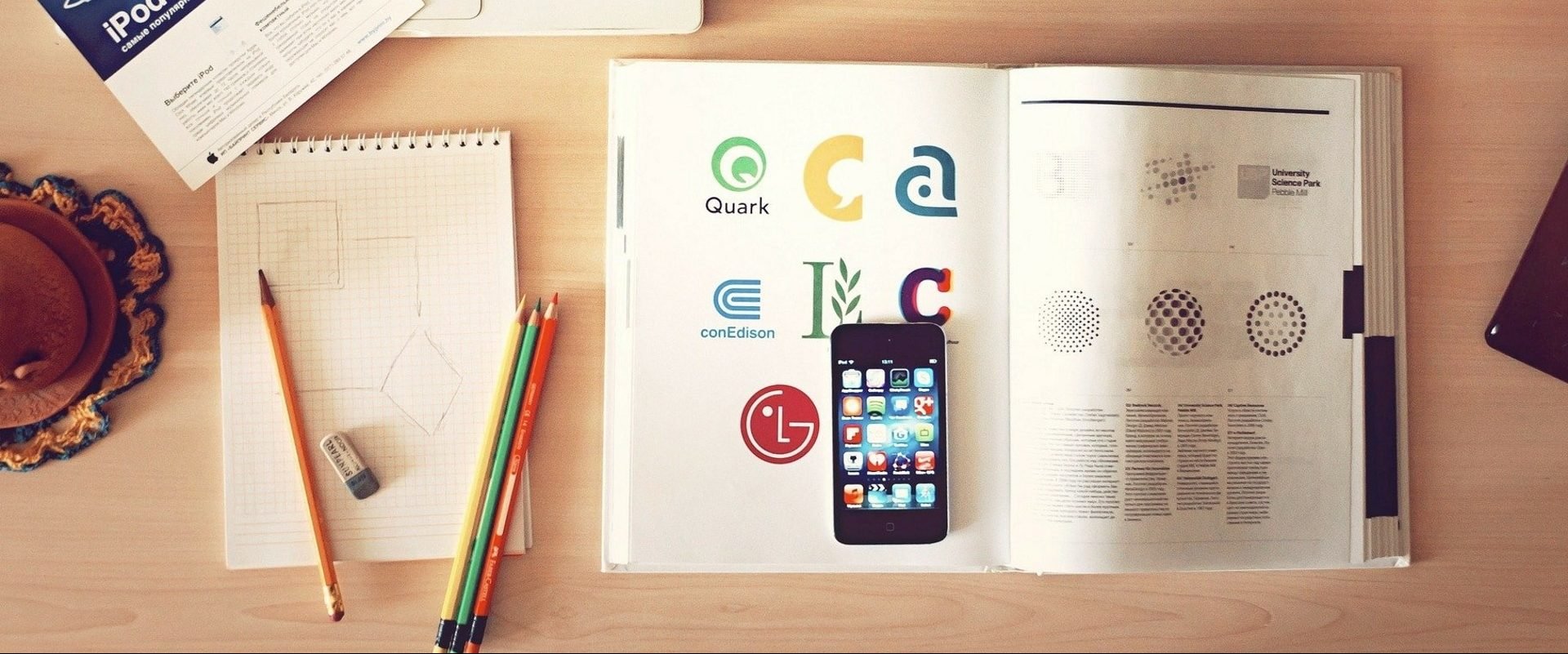 Imagem mostra mesa com livros, lápis, celular e tudo o que um aluno precisa para consultar os melhores aplicativos para ajudar a estudar e se preparar para o Enem