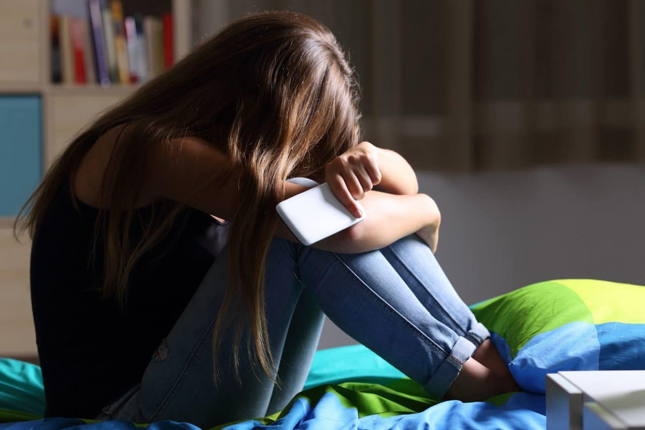 Adolescente triste após sofrer bullying online: imagem-conceito para matéria do TikTok