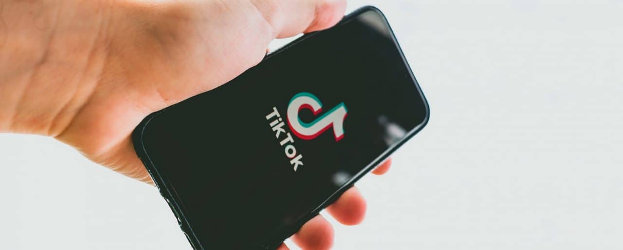 Imagem mostra mão segurando celular com TikTok, app mais baixado do mundo, aberto na tela